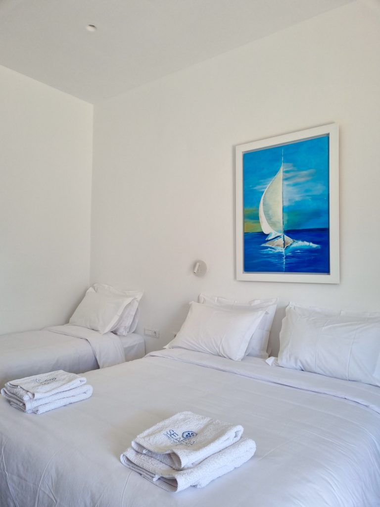 Υπέρδιπλο κρεβάτι με κομψή διακόσμηση στο Seaera Luxury Apartment στην Τήνο.